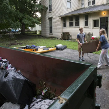 Loading waste material into dumpster bin